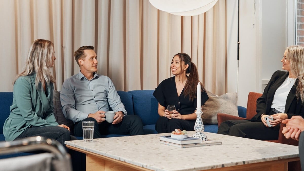 Four colleagues sitting in the lounge area chatting with each other